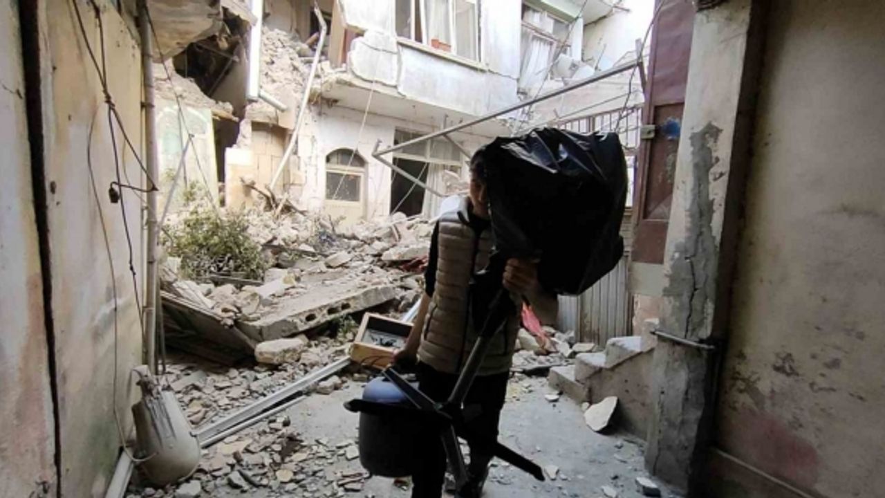 Suriyeli gencin harabeye dönen evinden eşya kurtarma çabası